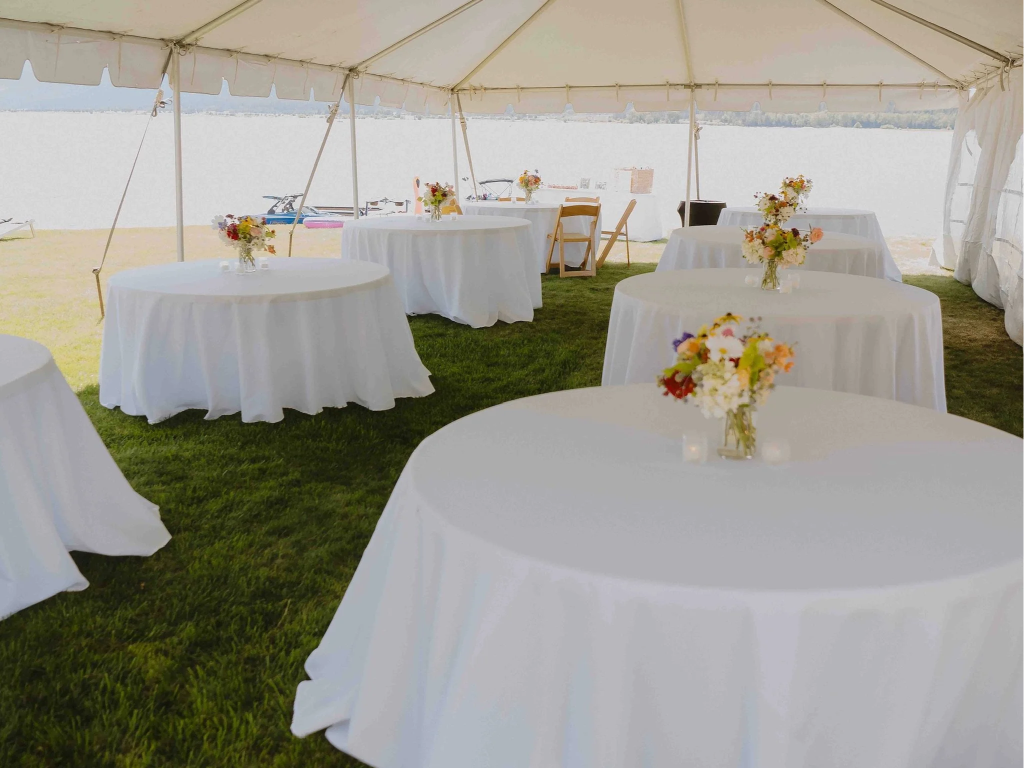 Interior of an event tent with tables set for a wedding reception