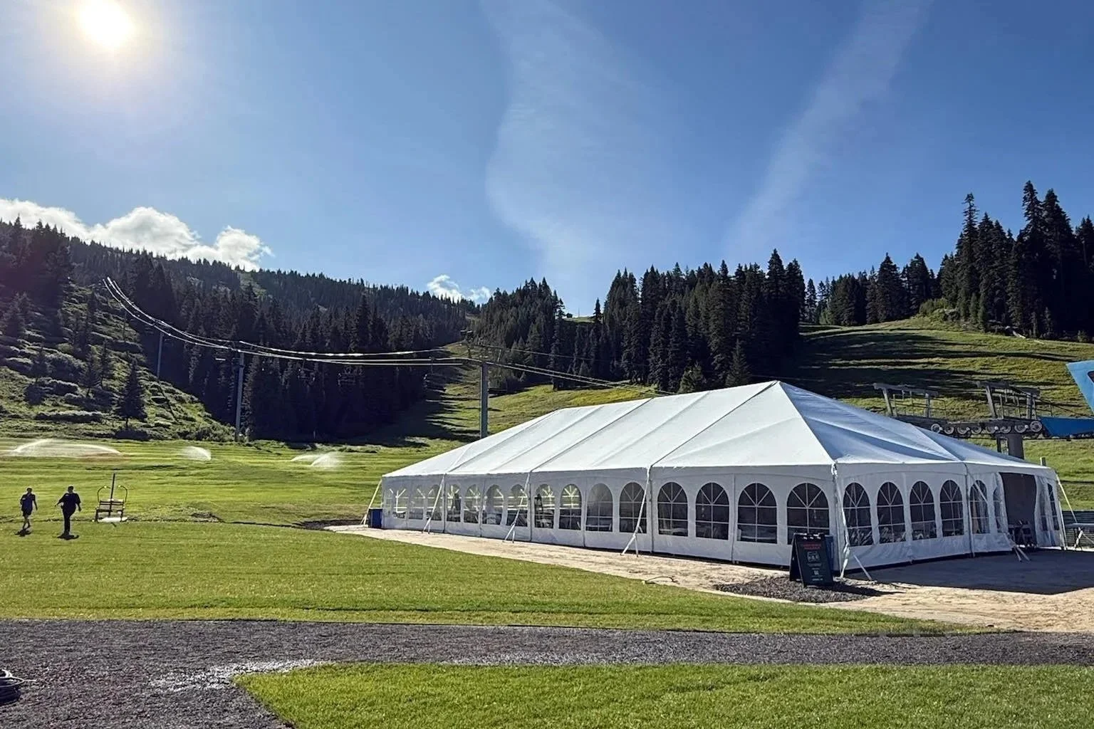Large event tent set on grass at the base of Brundage Mountain Resort