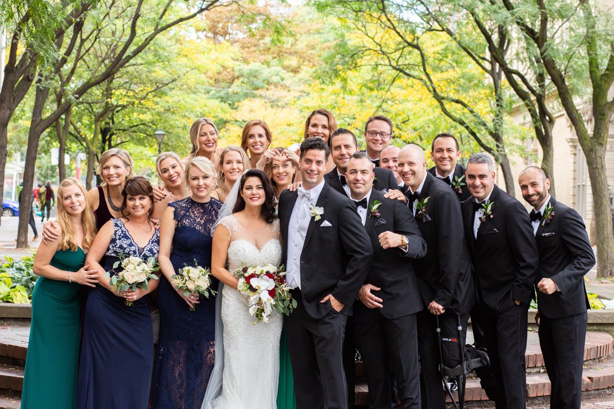 Bridal party photo of everyone gathered in a city park.