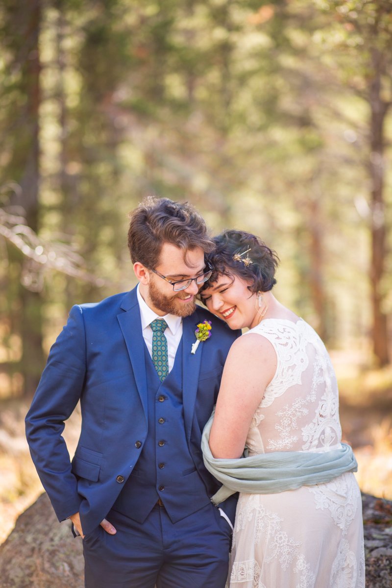 Couple laughs as bride snuggles up to groom.