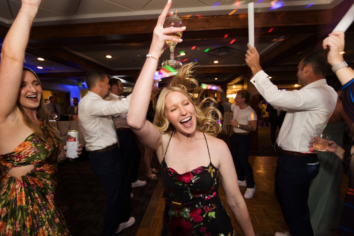 Jubilant dance floor scene of a blond woman dancing through a soul train formation.
