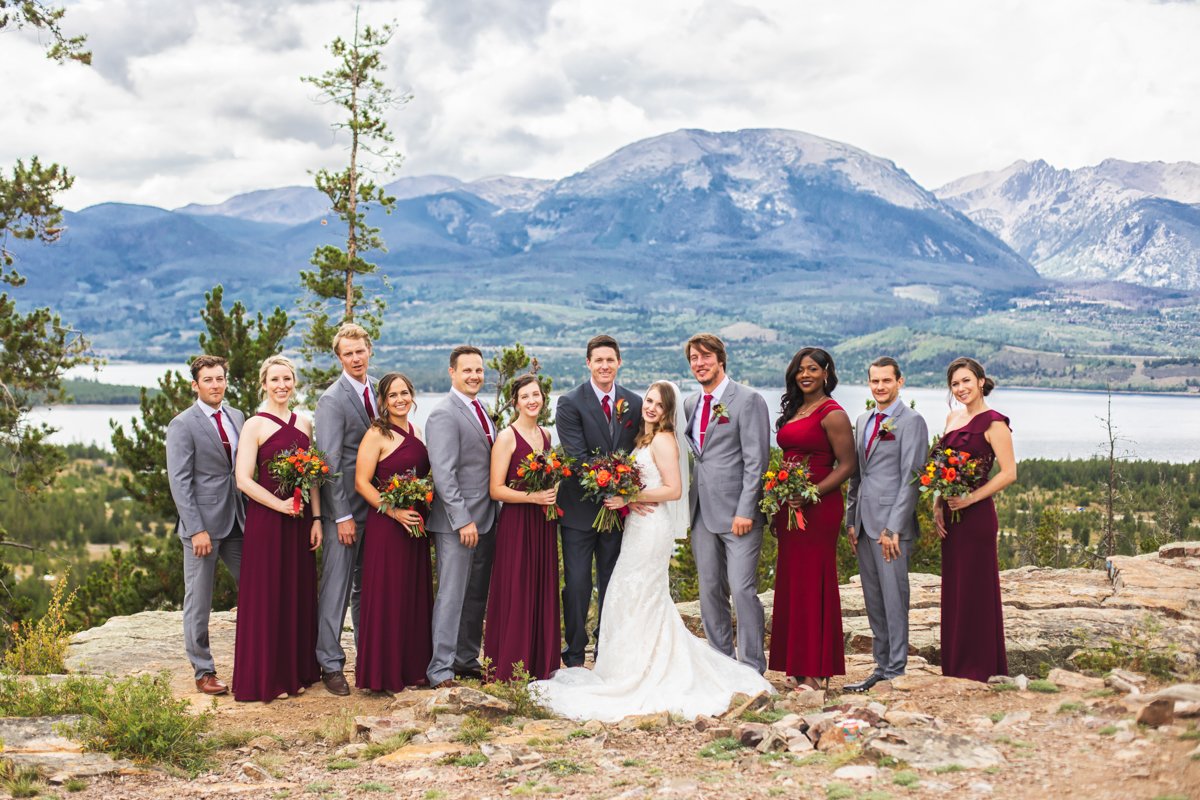 Wedding party in a scenic spot overlooking an alpine lake and mountains.