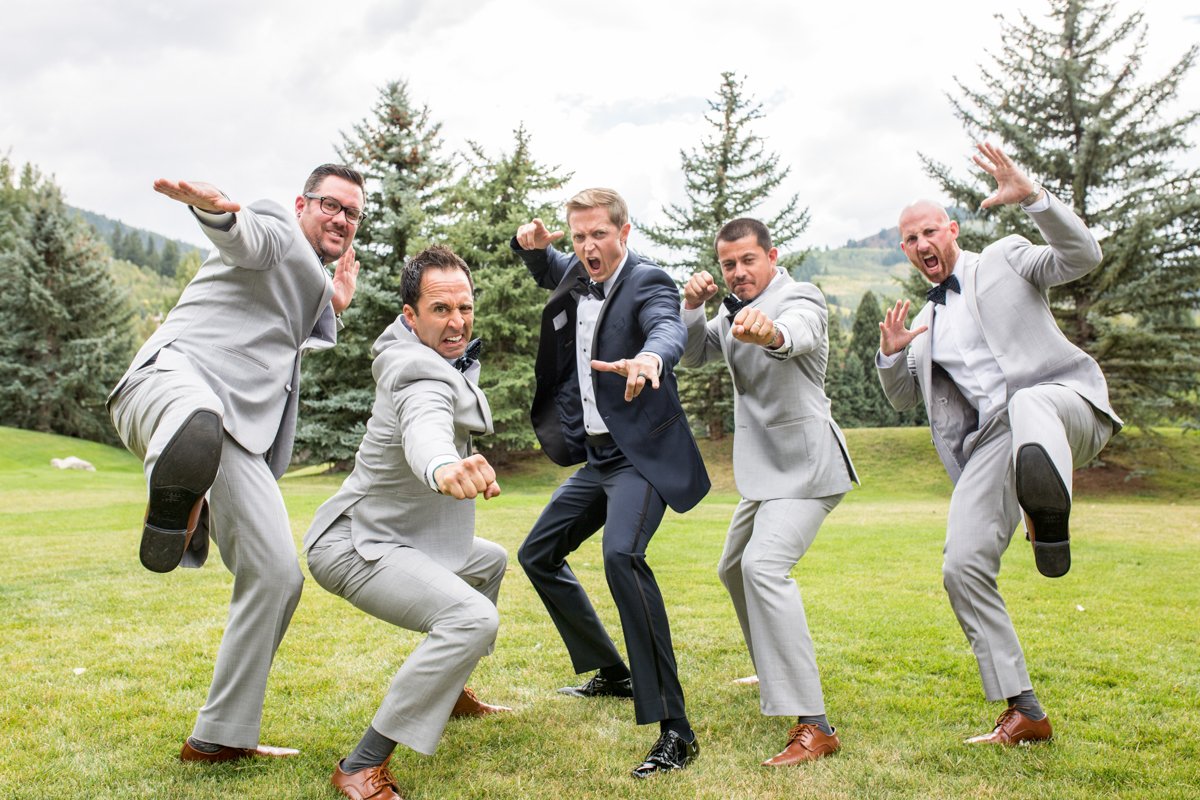 Groomsmen being goofy and jumping like karate kid at the camera.