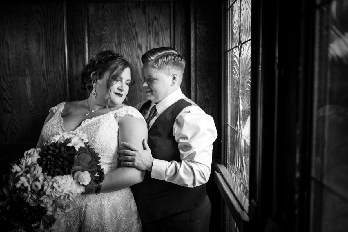 Couple next to a stained glass window. Dramatic window light on their faces.