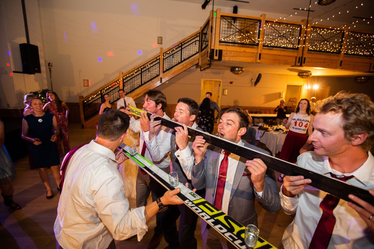 Wedding guests partake in a shot ski on the dance floor.