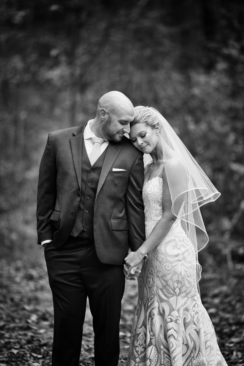 serene black and white image of a couple snuggled up holding hands.