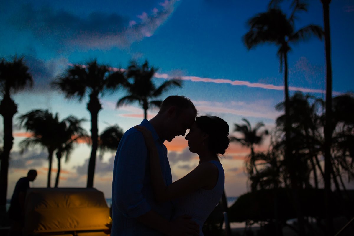 Silhouette of a couple among palm trees in Aruba.