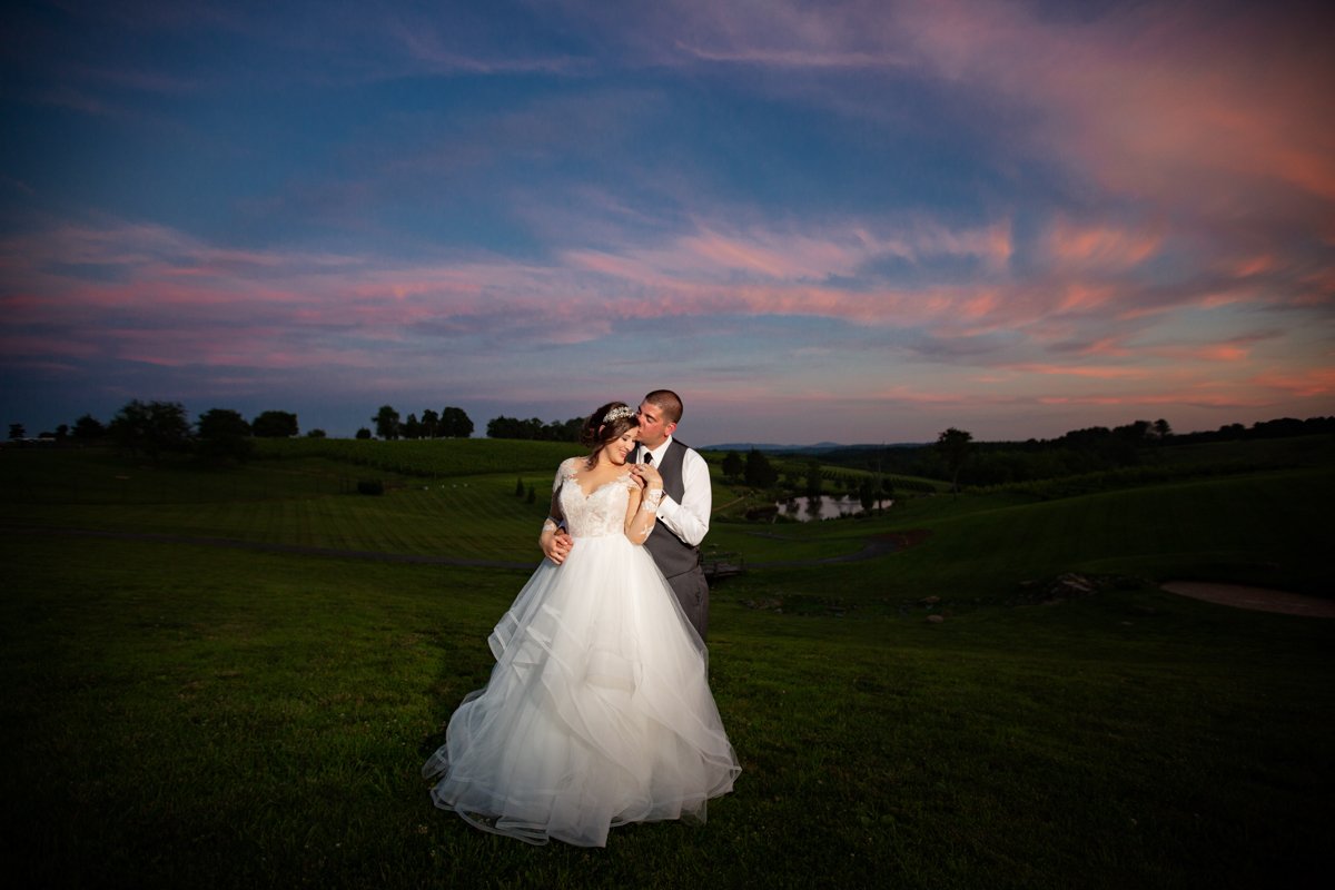 Couple outside at sunset in a vineyard.