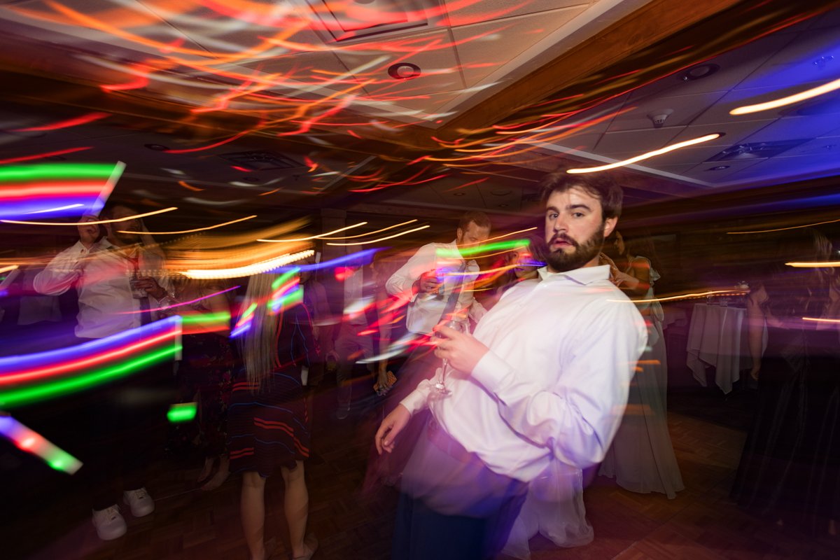 Dragged shutter with colorful light streaks of a dance floor scene.