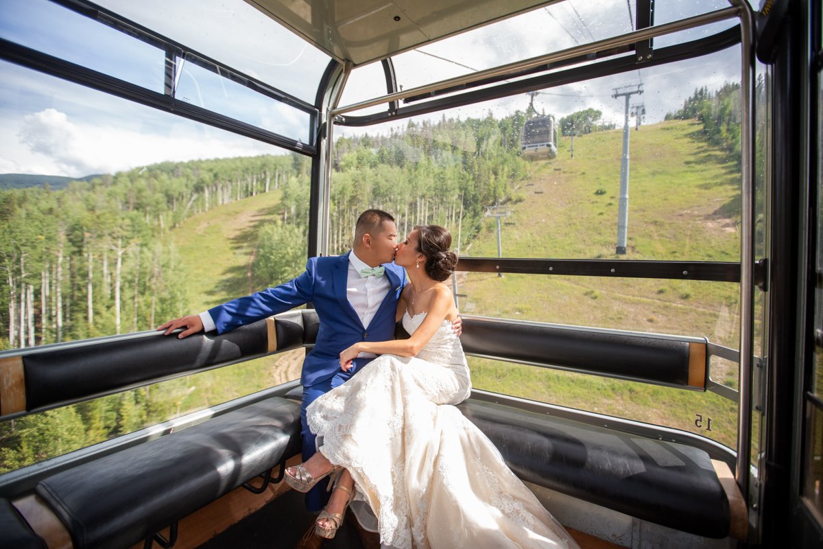 Couple kiss inside a gondola ski lift at Vail Mountain on their way to their ceremony.