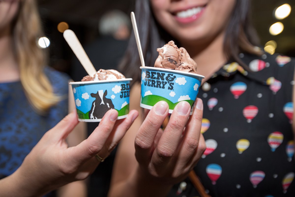 Wedding guests holding mini ben and jerry's ice cream cups on the dance floor.