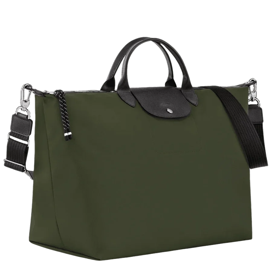 Green handbag with black handle and adjustable black strap, silver hardware, and black and white polka dot zipper pull.