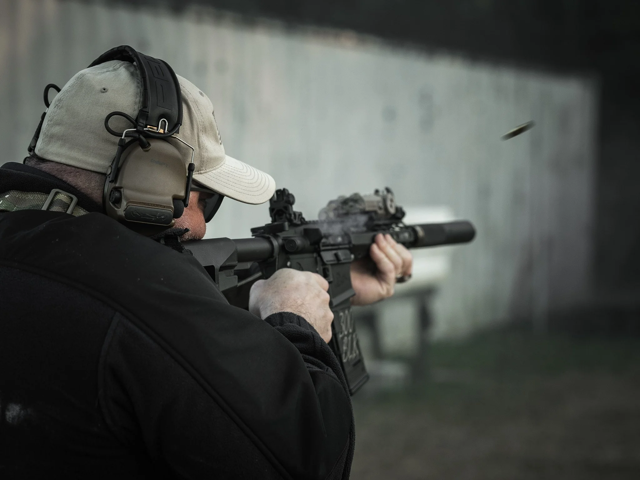 A man shooting a suppressed 300BLK AR pistol.