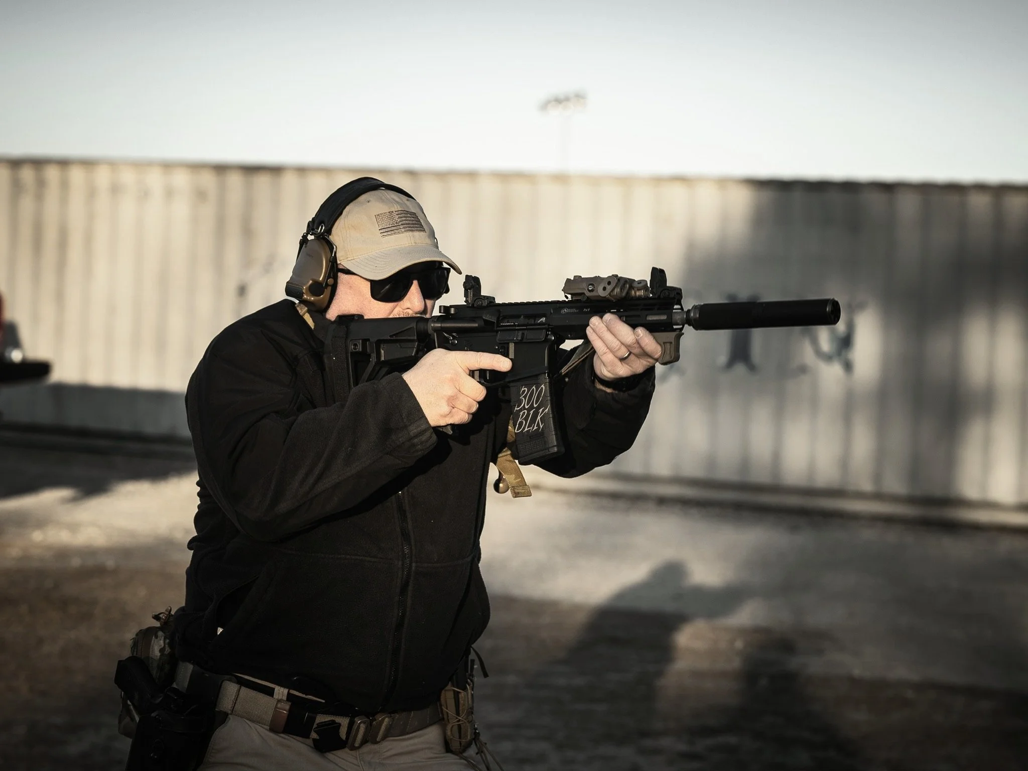 A man shooting a .300blk AR pistol with a suppressor.