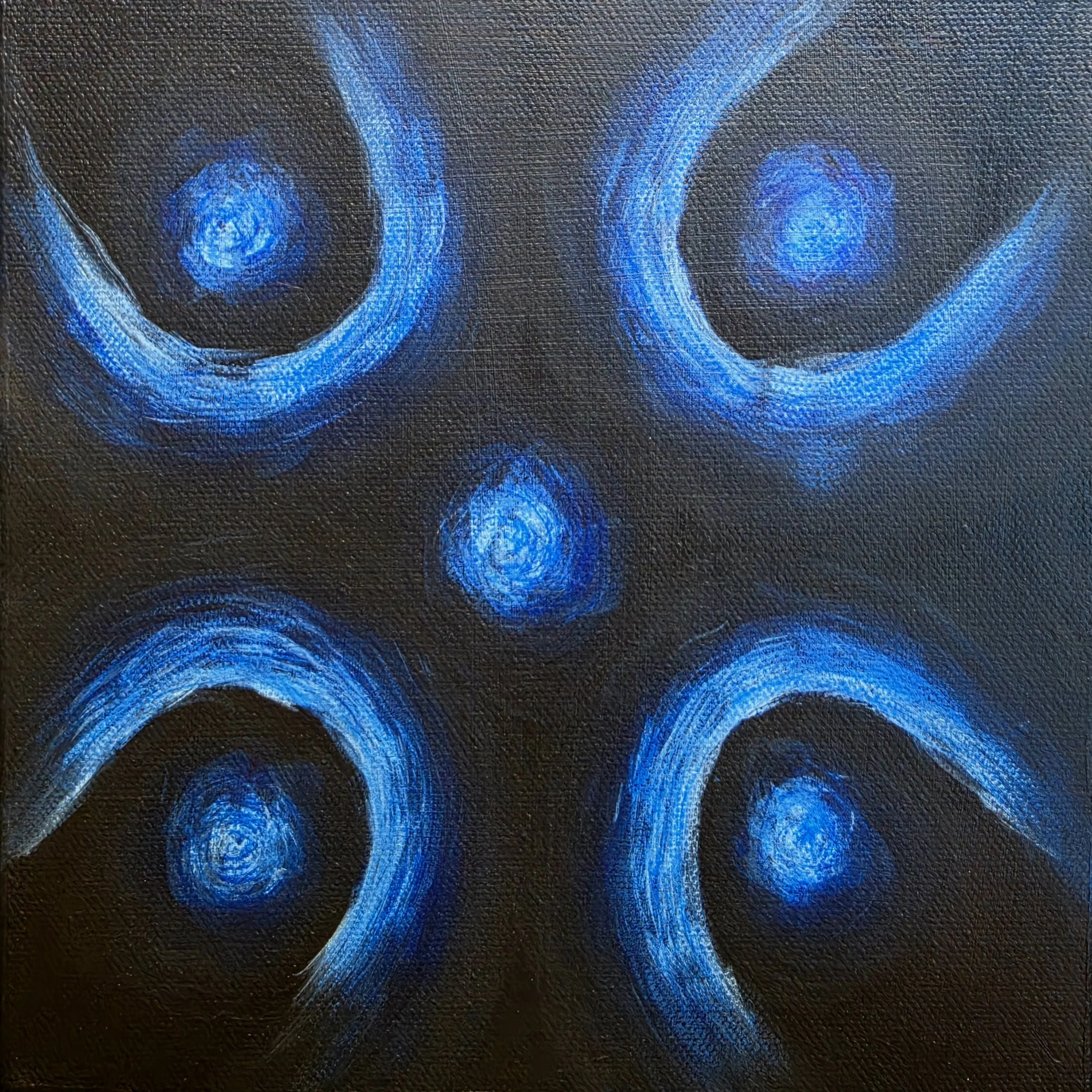 Close-up of a black textured surface with blue swirling abstract patterns painted on it.