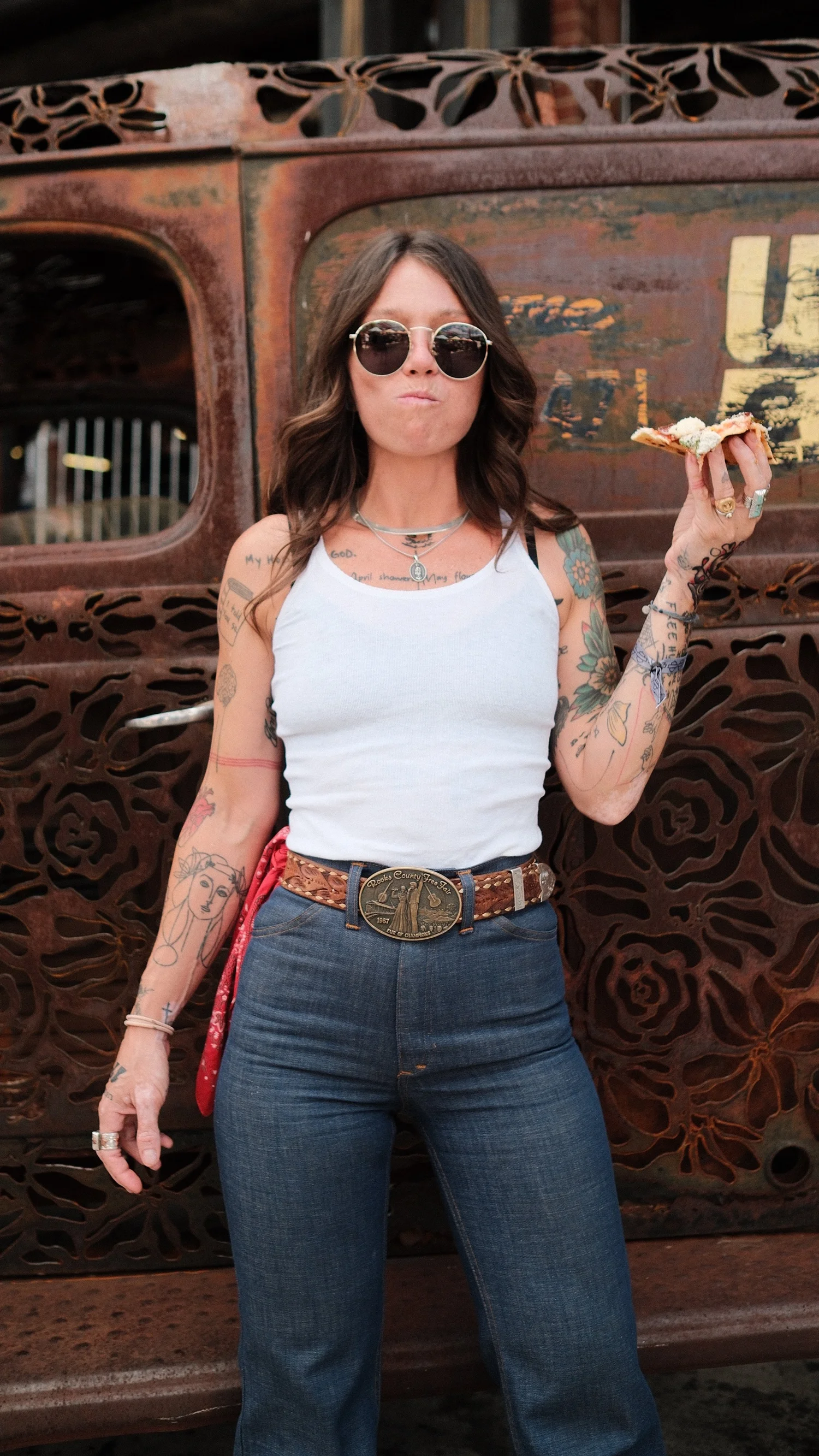 Rae Ripple eating pizza beside a vintage truck