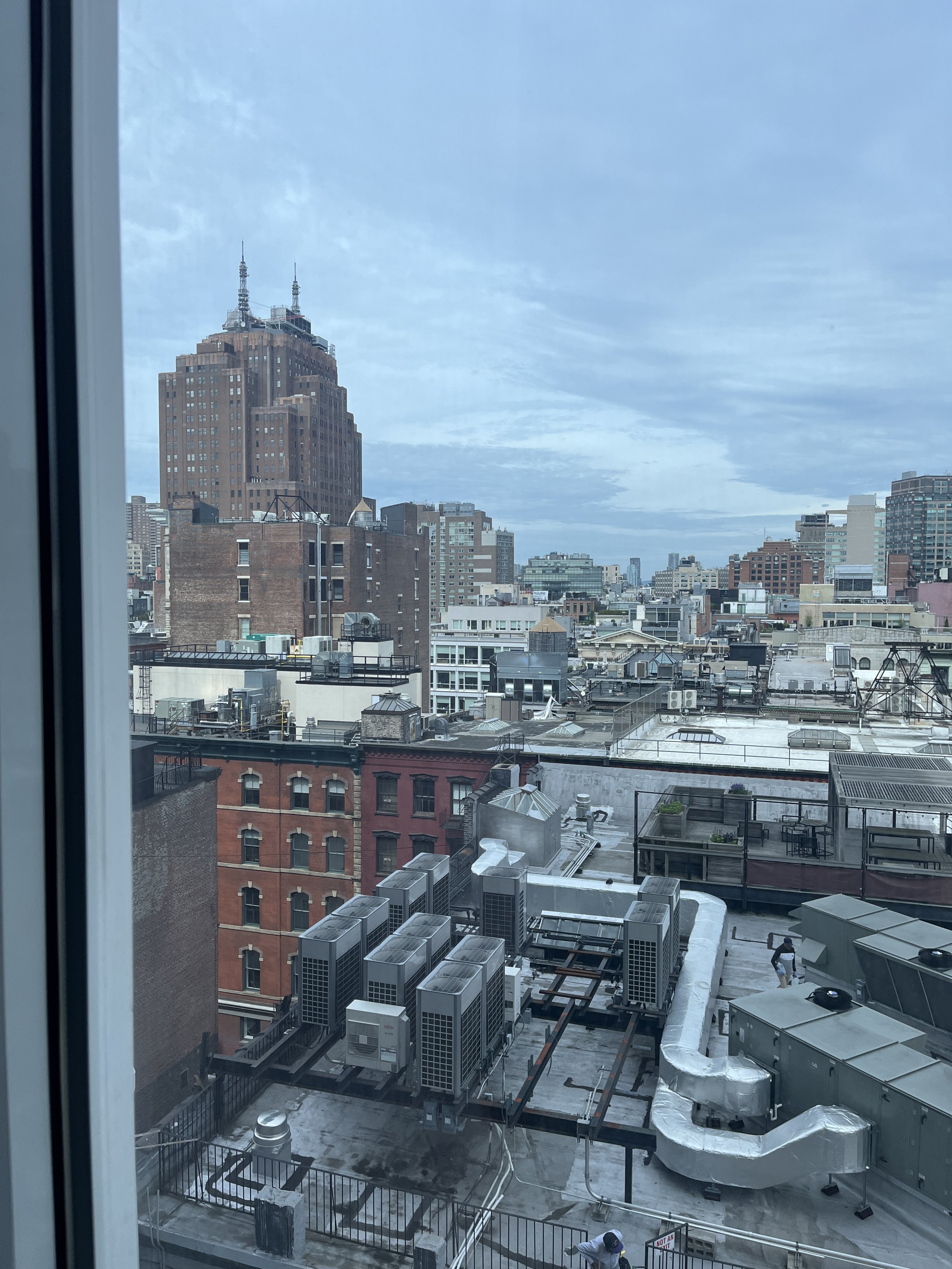 Urban cityscape view with brick buildings and rooftop equipment on a cloudy day.
