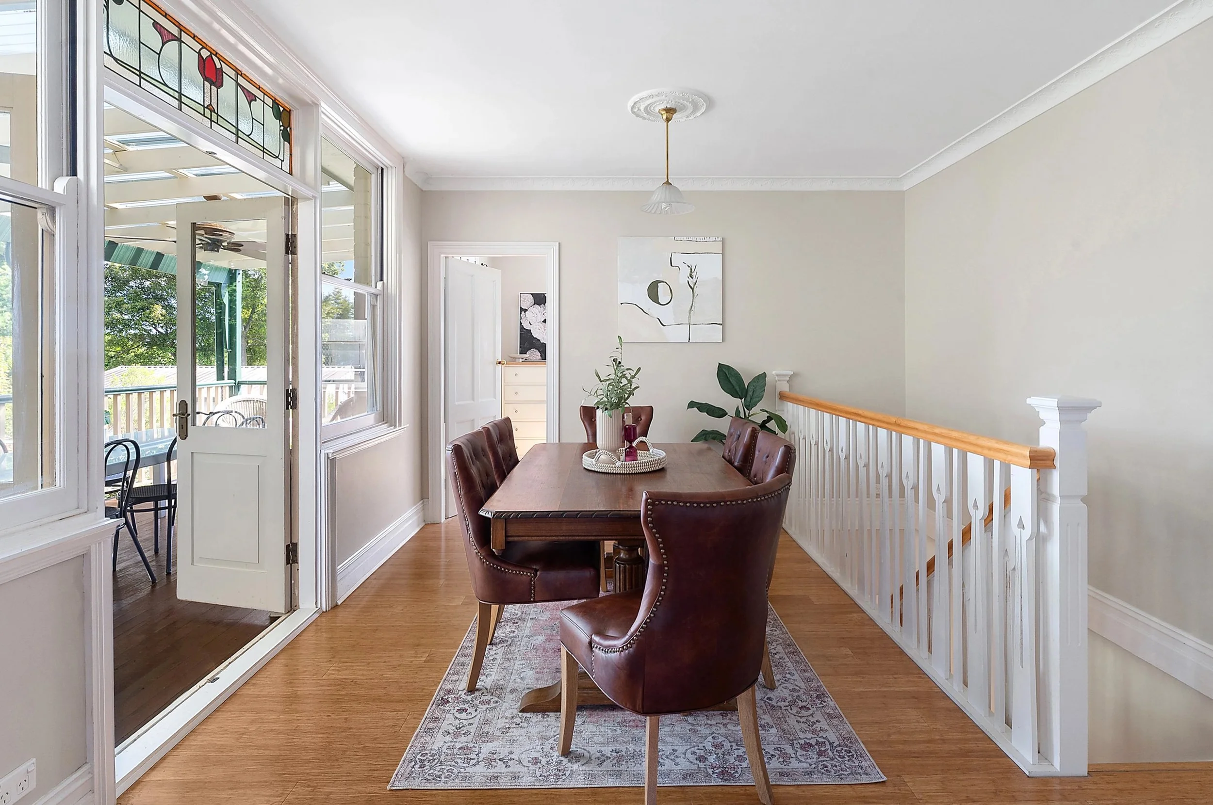 Dining room with a wooden table and six brown leather chairs.
