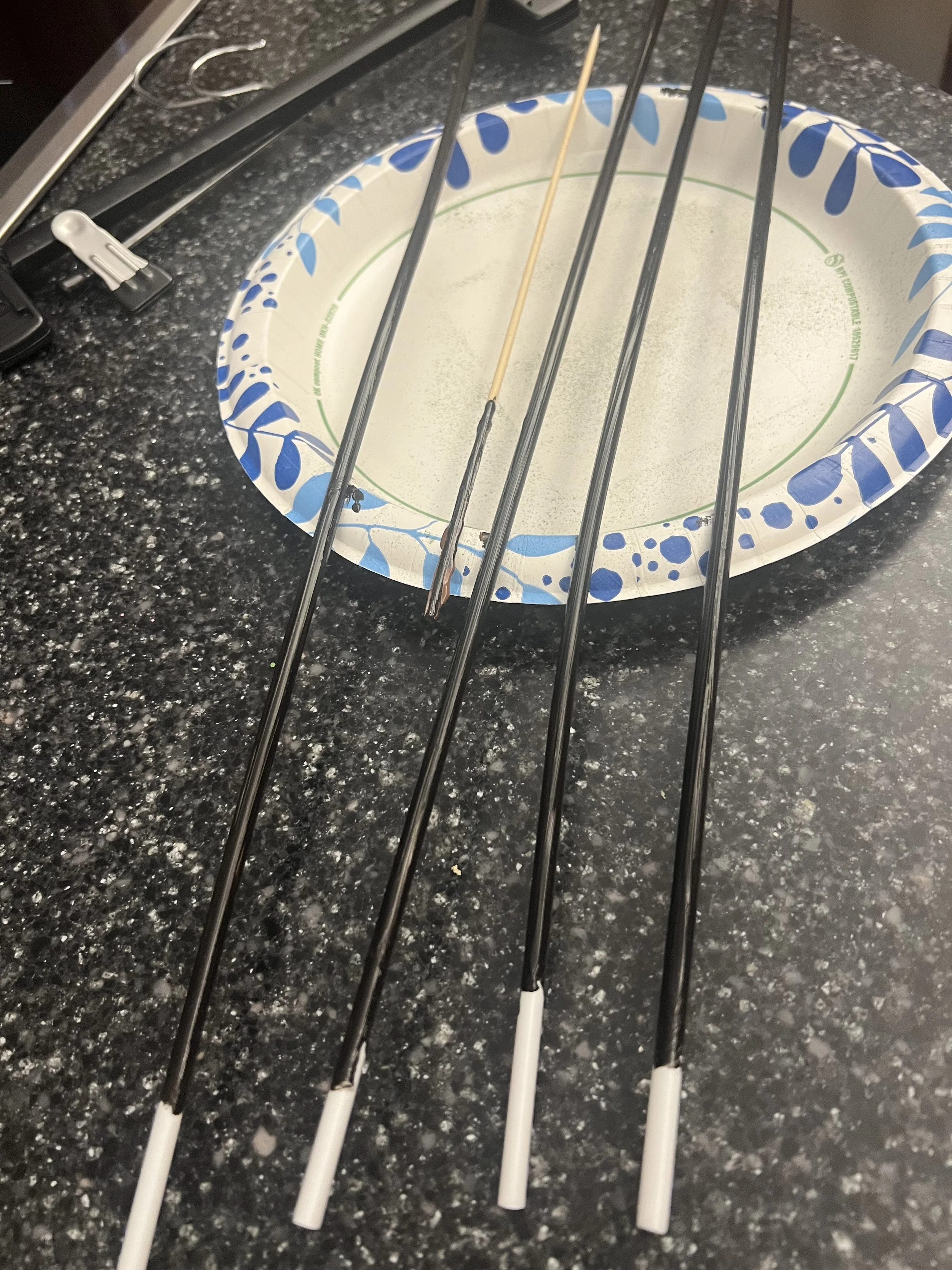 Mini foam football stress balls on painted wooden dowels for a DIY floral arrangement.