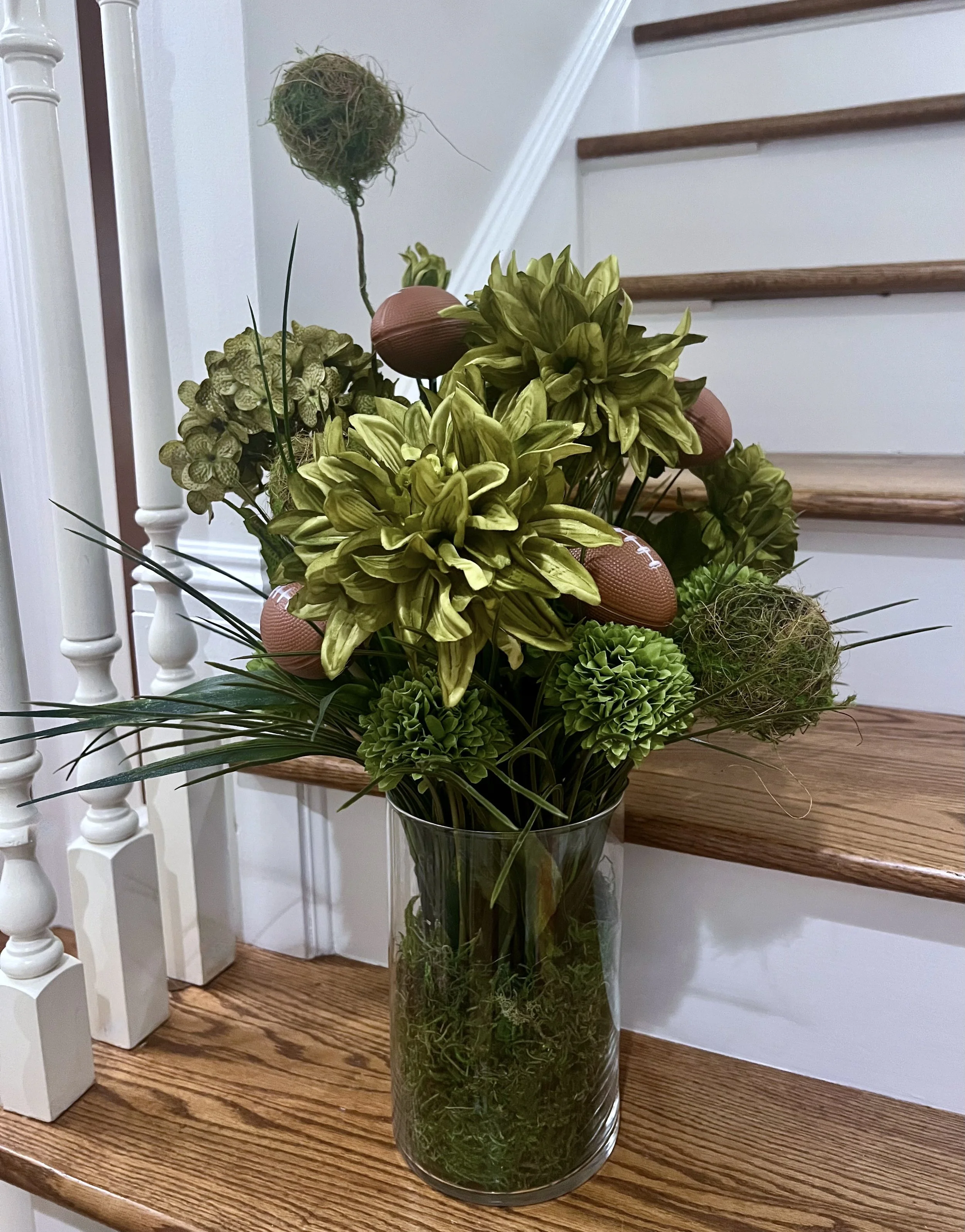 DIY football floral arrangement with mini footballs and greenery on a staircase in Franklin, TN.