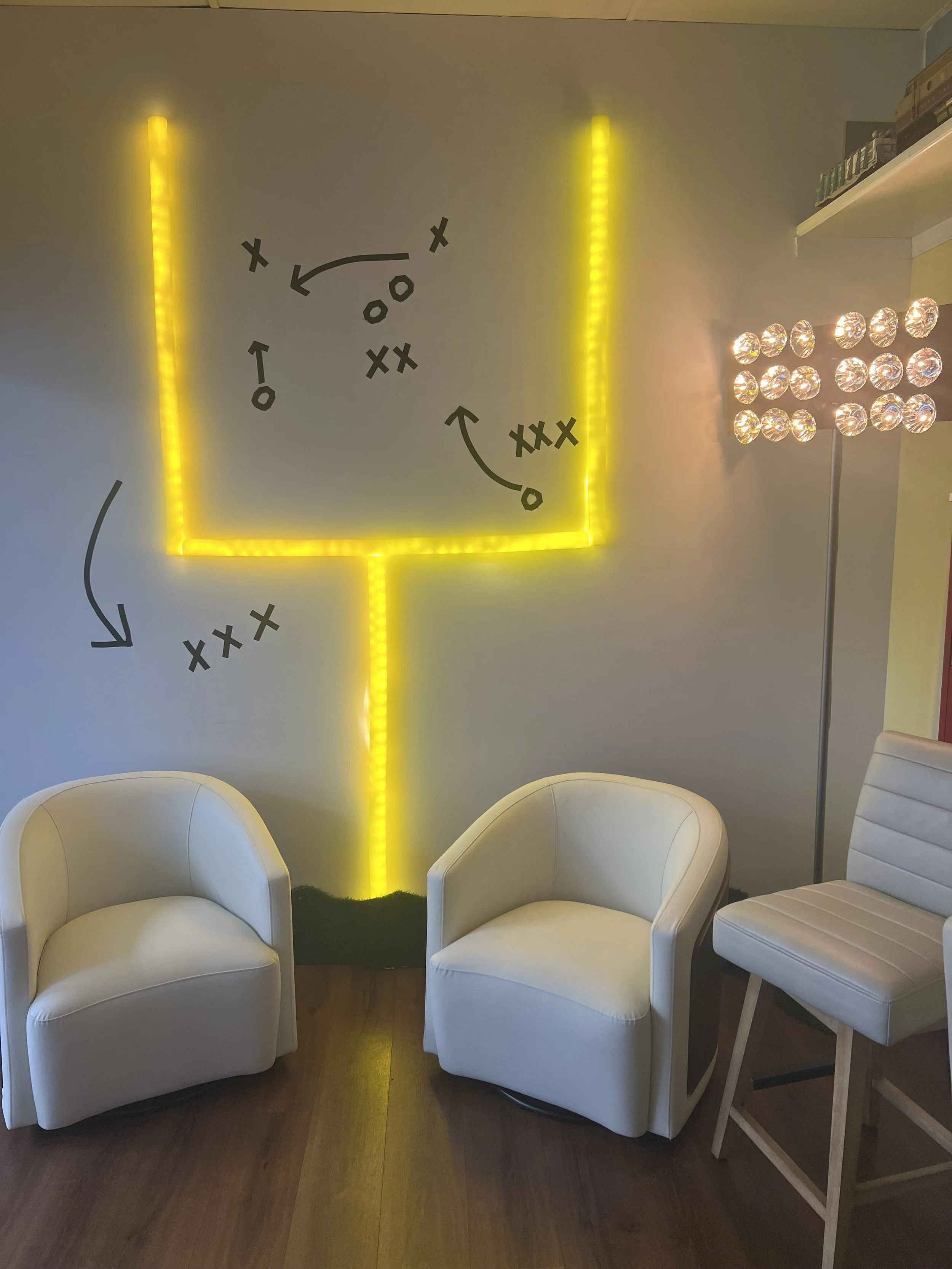 DIY glowing football goal post wall with LED lights, pool noodles, and game-day seating setup.