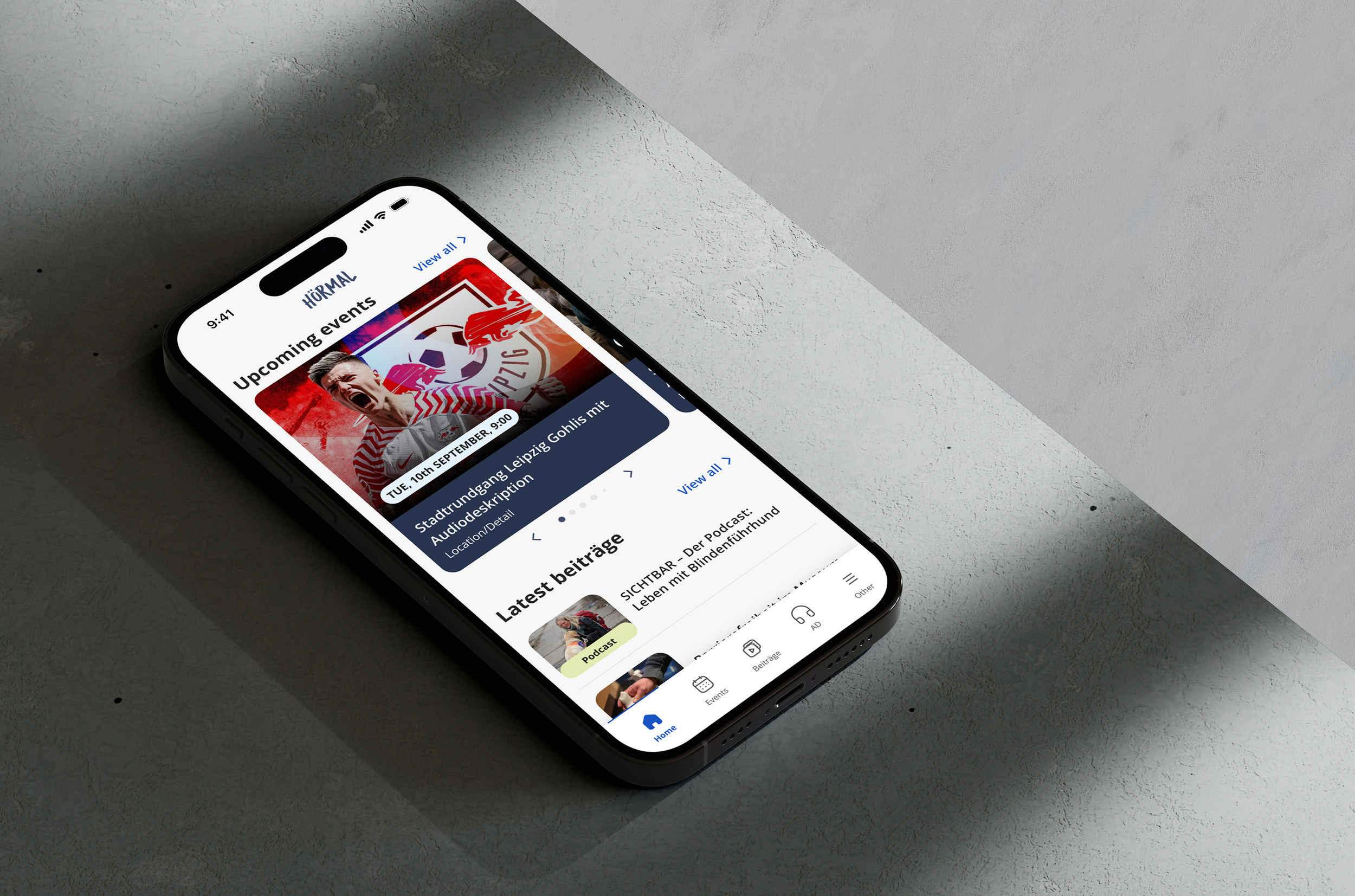 Smartphone displaying a sports event app interface on a textured surface, showing upcoming events and podcasts with navigation icons at the bottom.