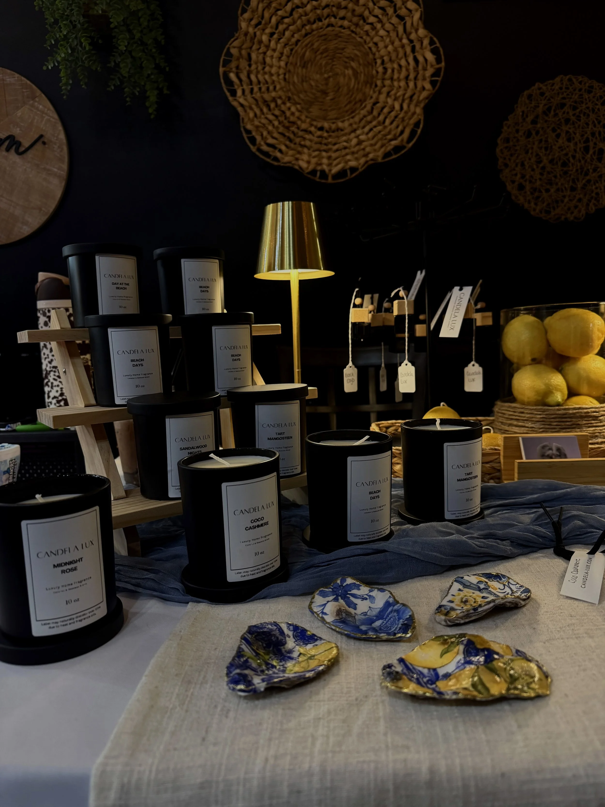 A display of Black Label Signature Scent Line by Candela Lux Candles at a local Rhode Island vendor event.