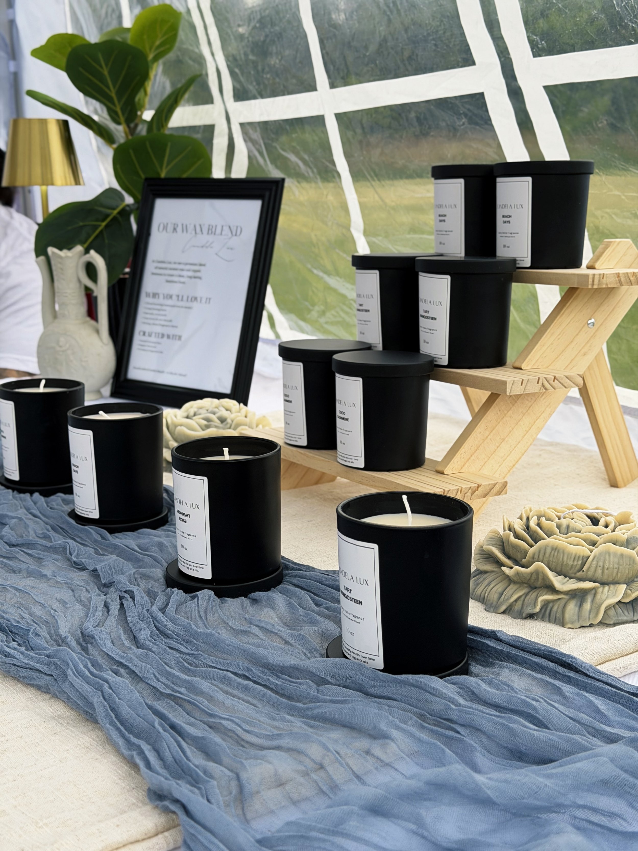 Display of Black Label Signature Scent Line. 10oz glass vessel with your choice of scent: Coco Butter Cashmere, Beach Days, Midnight Rose, Tart Mangosteen, and much more!