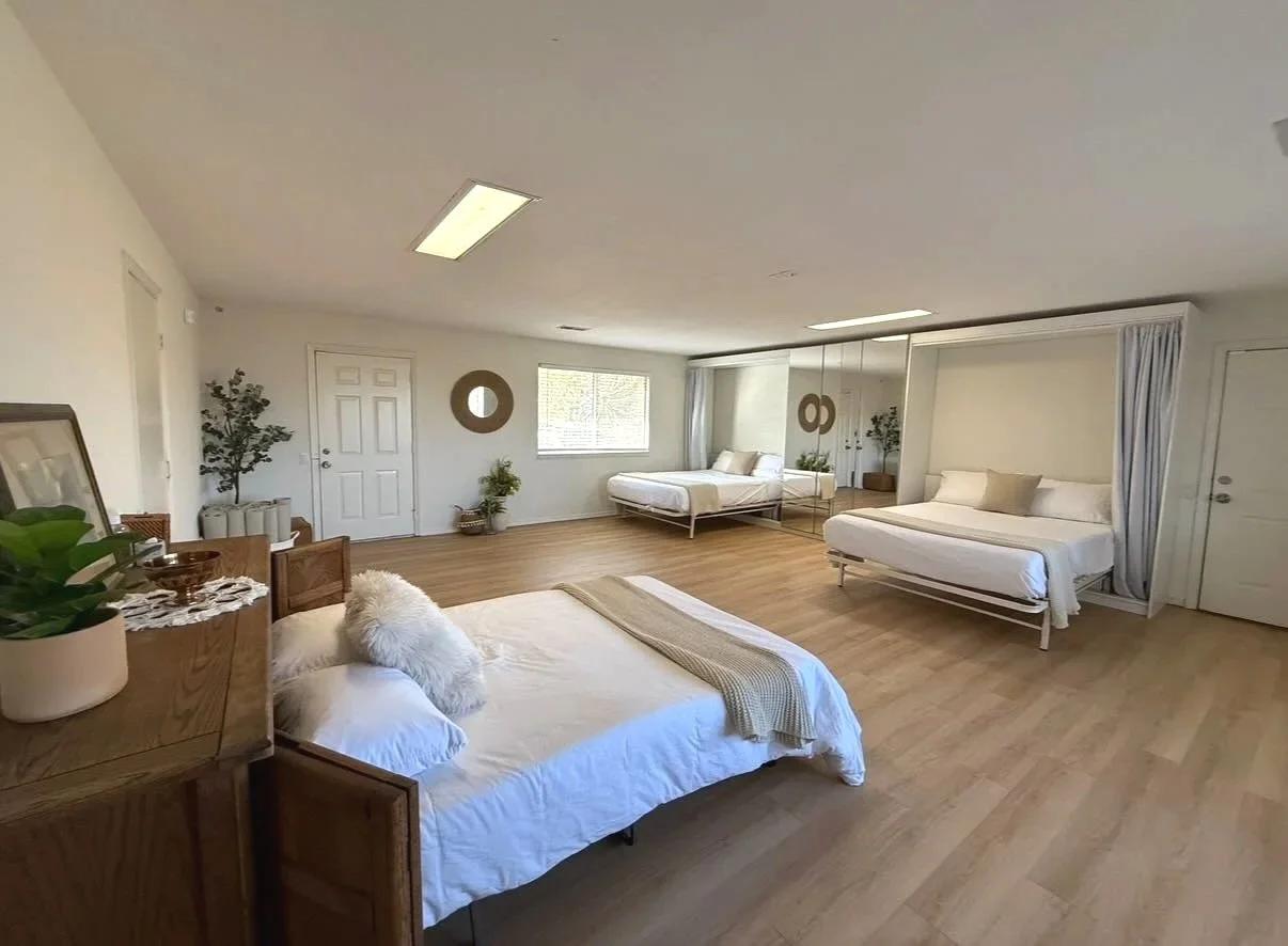 Two Queen sized Murphy beds, opened up in a large room.