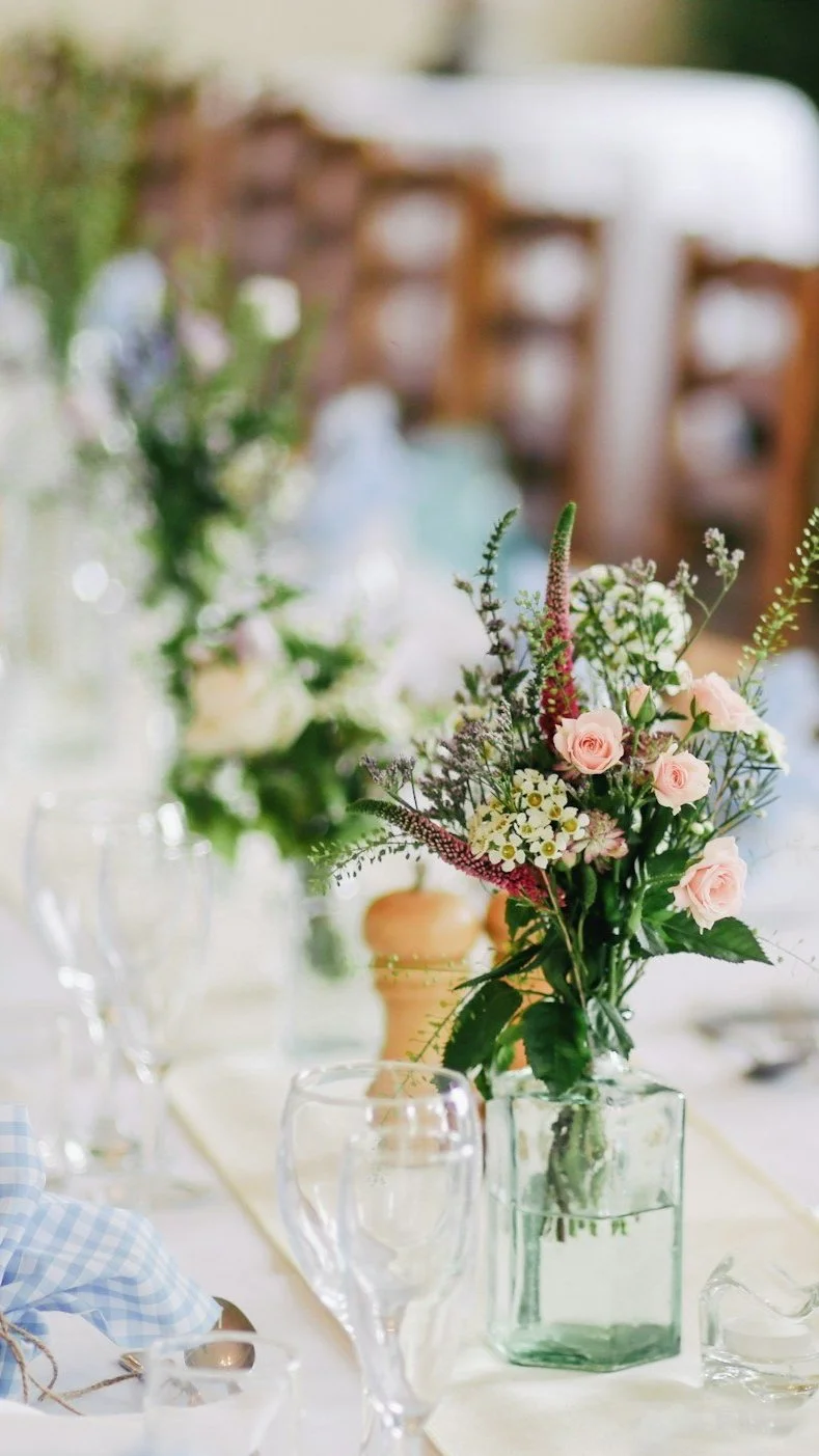 Elegant table setting with floral centerpiece and glassware at an event.