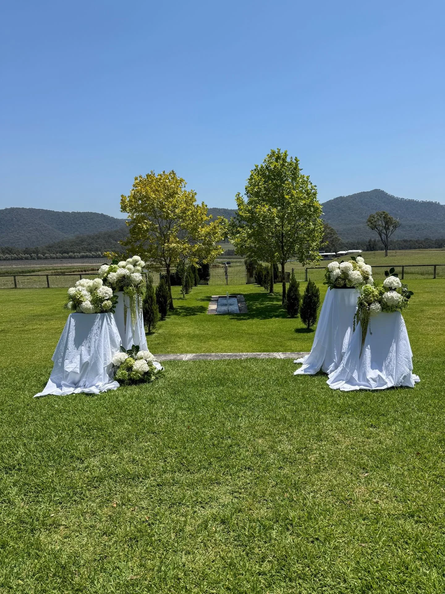 Still not getting over this 🤍

Ceremony blooms for the most beautiful &ldquo;I do&rdquo; setting. Soft white hydrangeas, fresh seasonal greens and a timeless aisle framed by nature. Simple, elegant and designed to let the view do the talking.

Enqui