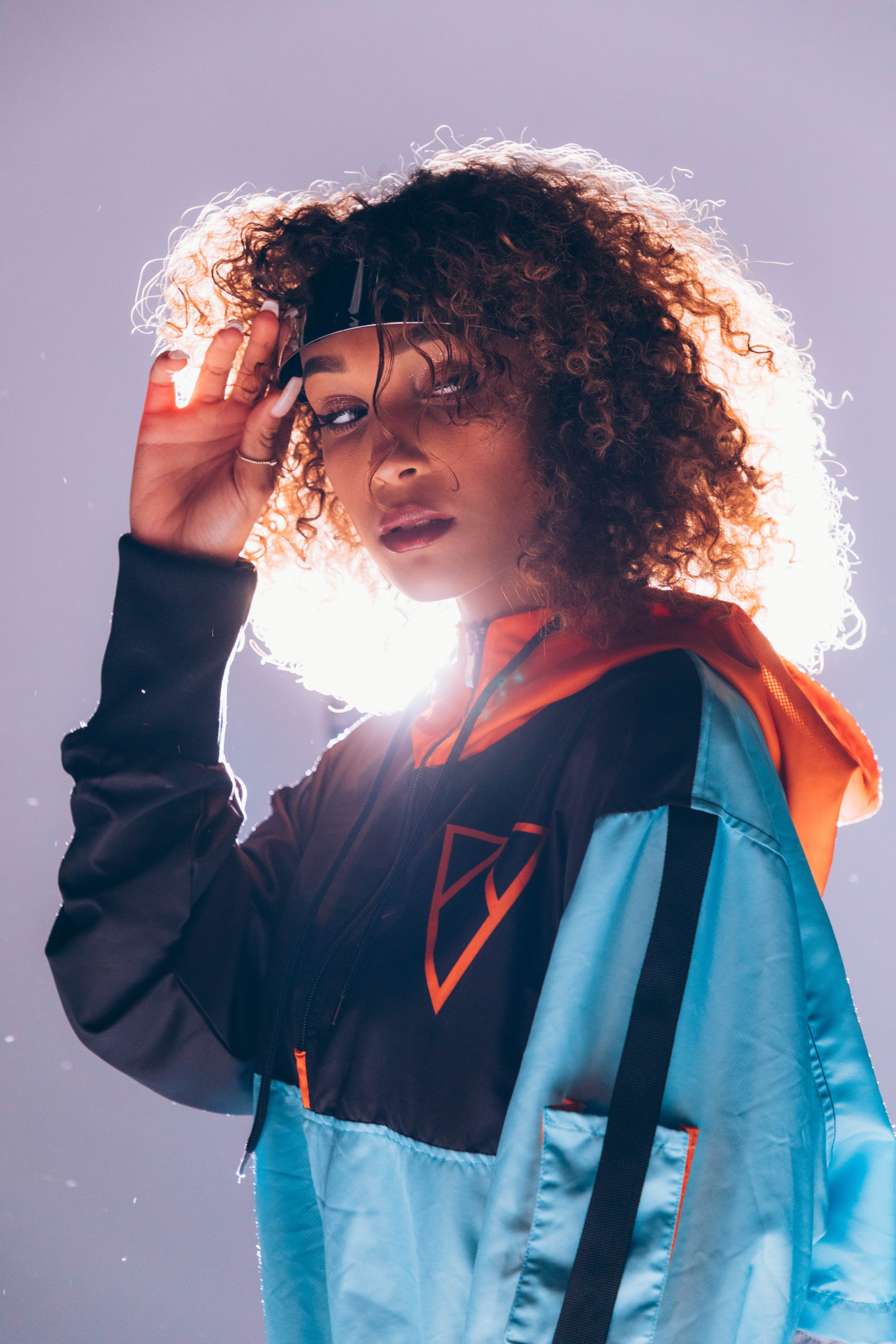 Woman in futuristic Vurtual windbreaker posing under soft lighting