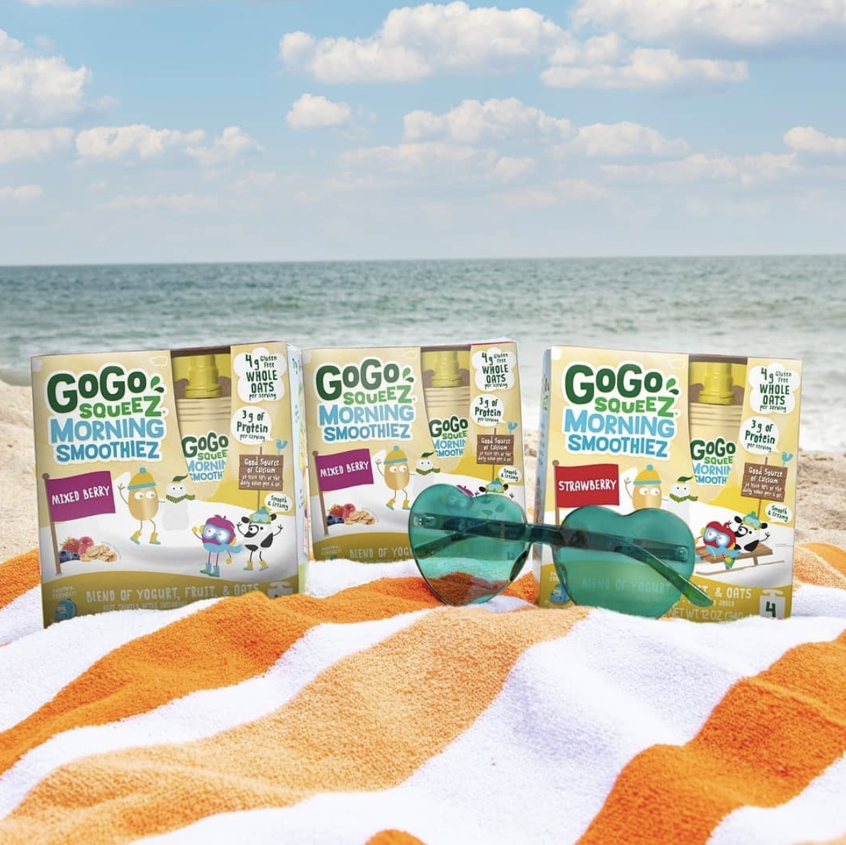 Three boxes of GoGo squeeZ Morning SmoothieZ toddler snacks with sunglasses and an ocean background