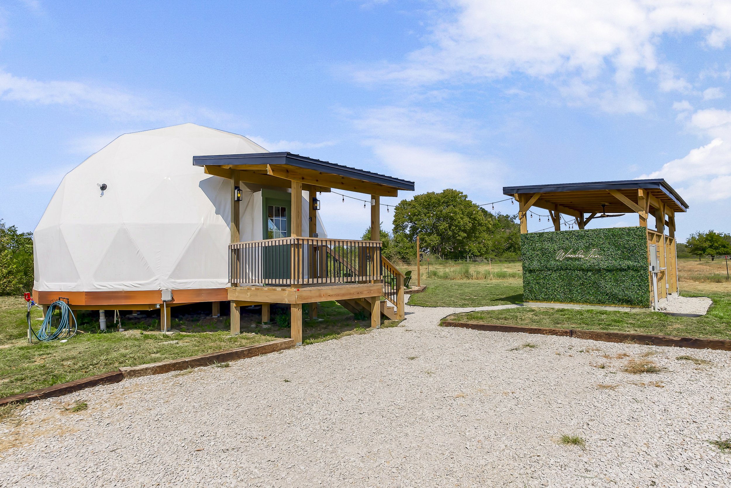 Wander Inn geodesic dome with its front deck and separate covered hot tub gazebo near Butler, Missouri
