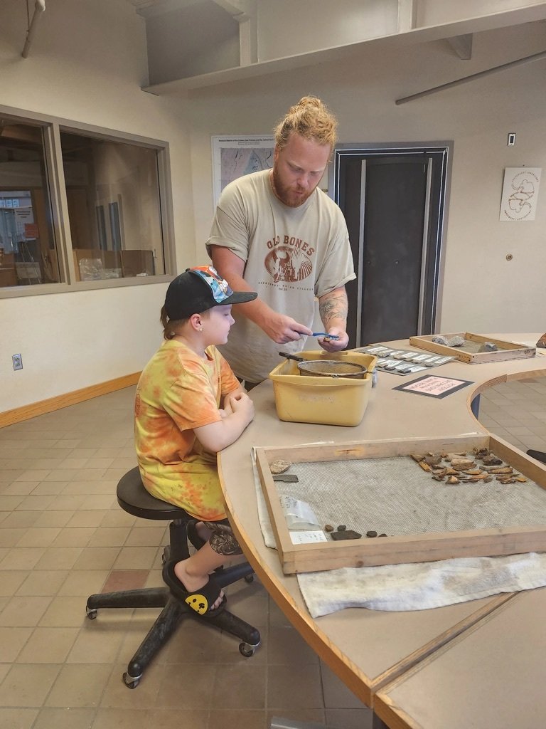 Christian New (then Archaeology Intern) with a young visitor, 2023