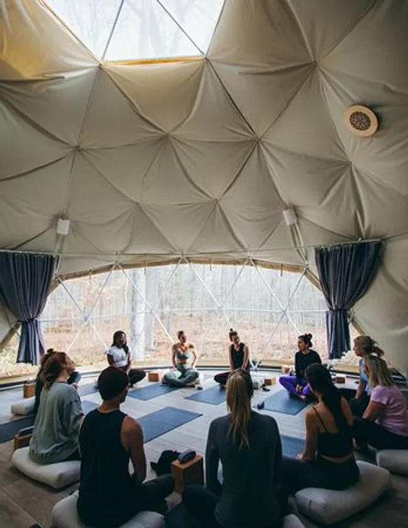Guided group practice in the geodesic dome—connecting breath, presence, and nature.