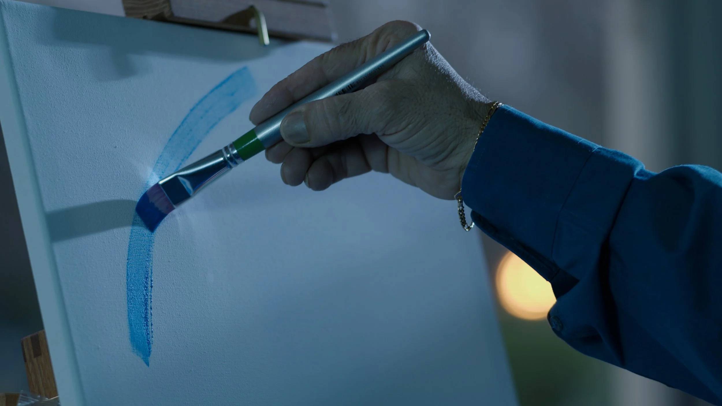 A painting hand works the canvas for this Melbourne documentary.
