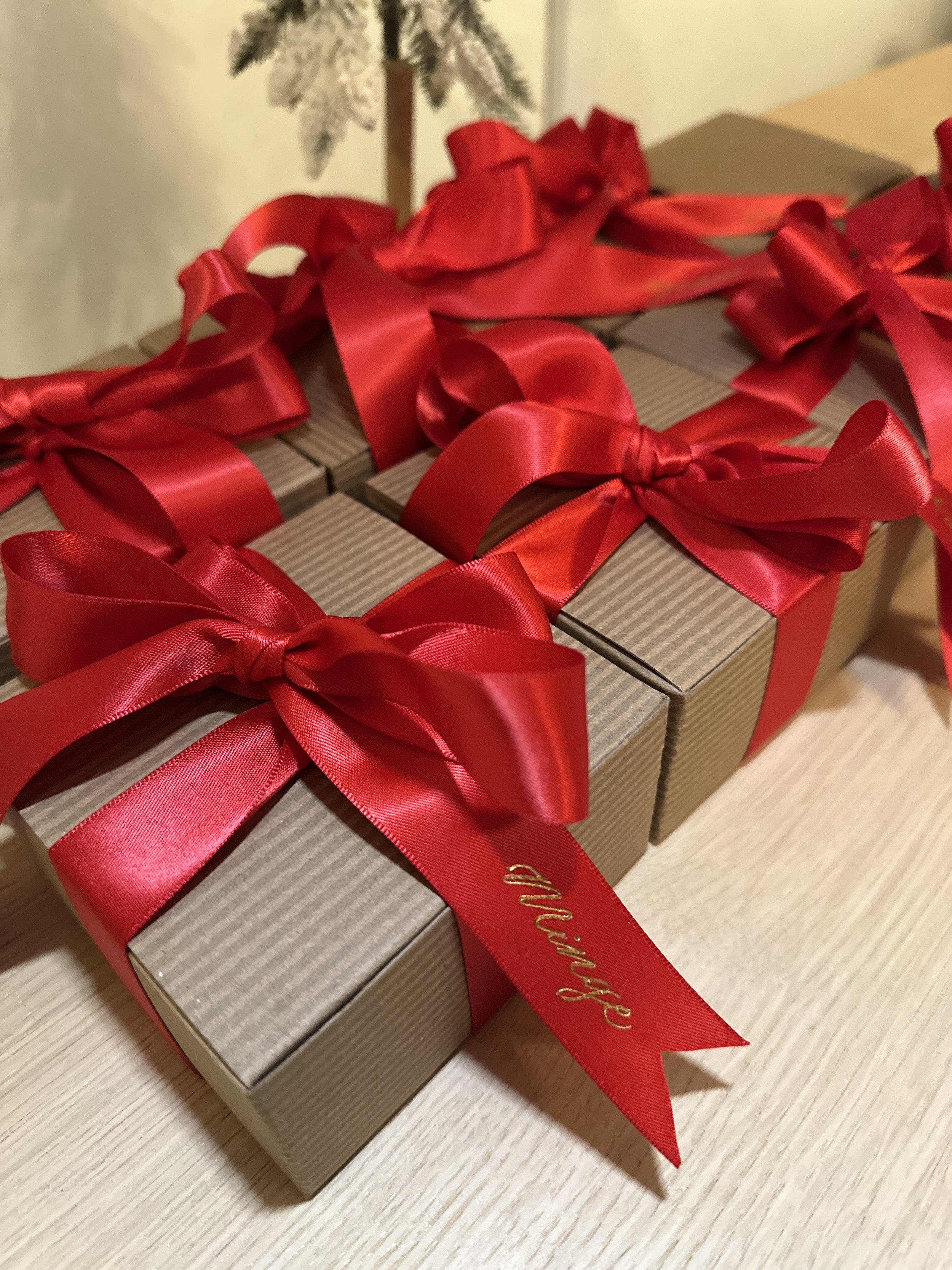 Personalized gold heat-foiled red ribbon on a wrapped gift for Christmas.