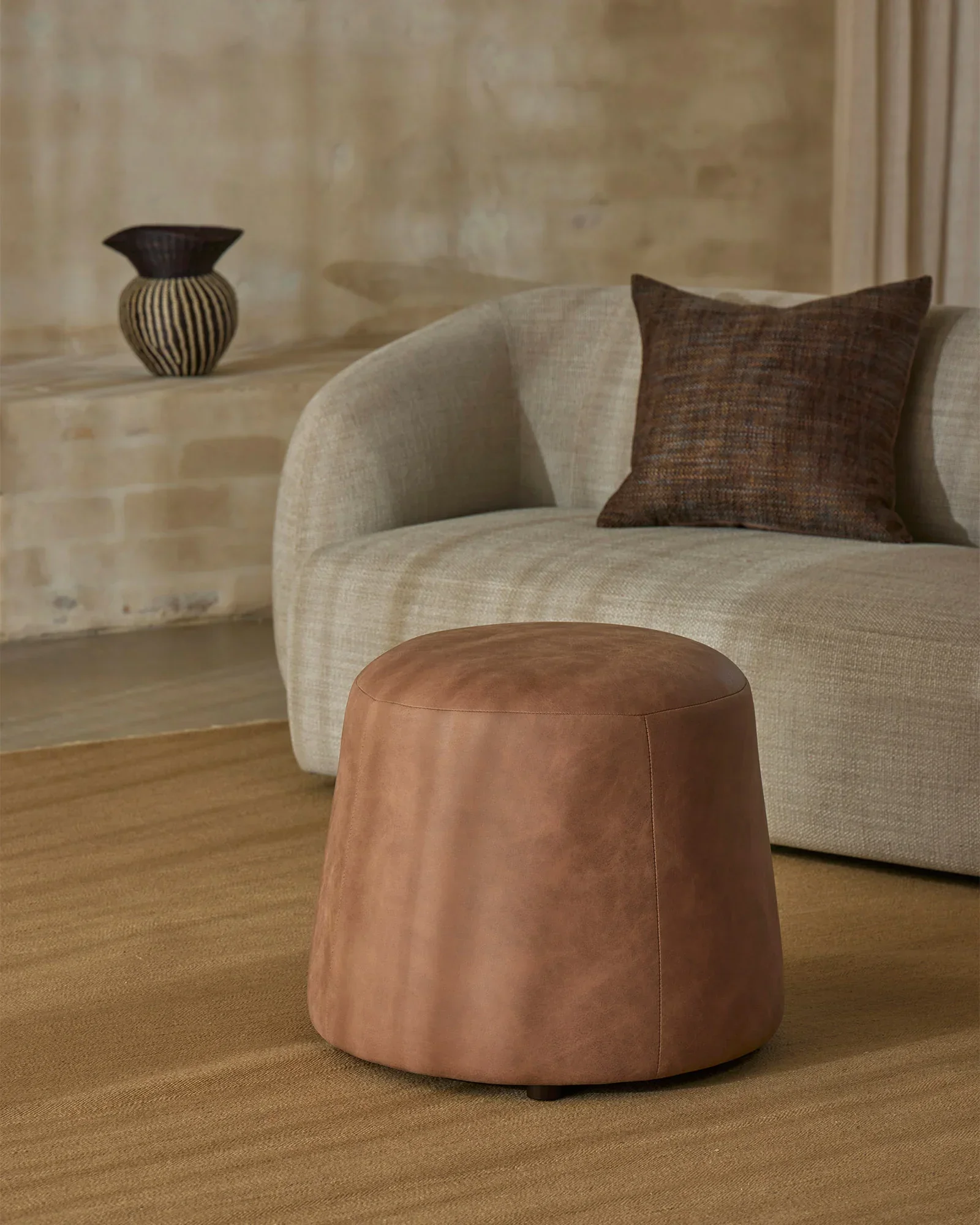 recklt912MOiqKgLz_recL5XeBDoTrOMf7z_Jacqueline-Brulee-Castel-Auburn-Landro-Toffee-Ottoman-Lifestyle1.webp