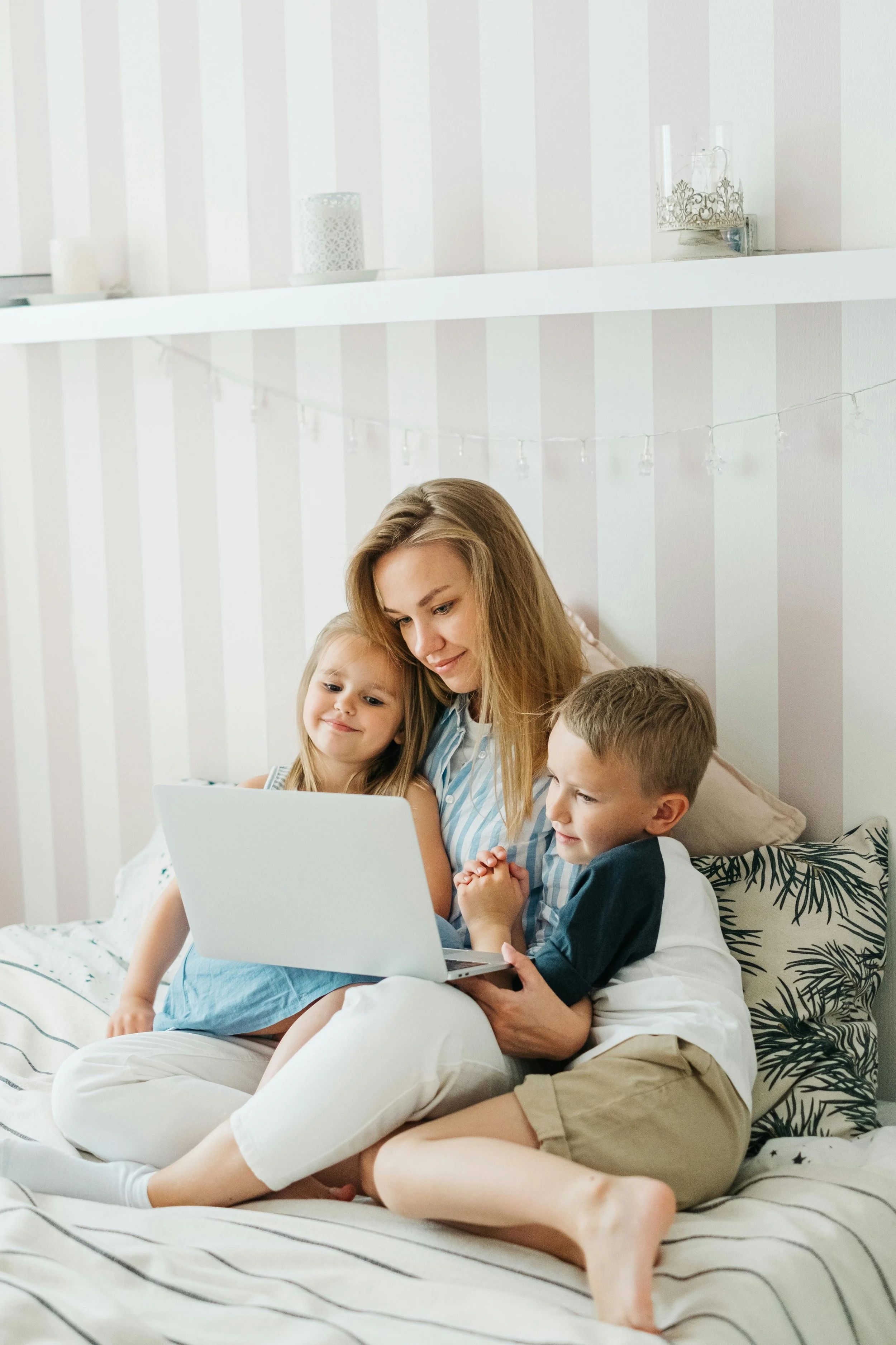 Smiling mother and two children using a laptop together on the sofa – reflecting timely, trusted ADHD and autism diagnosis for families.