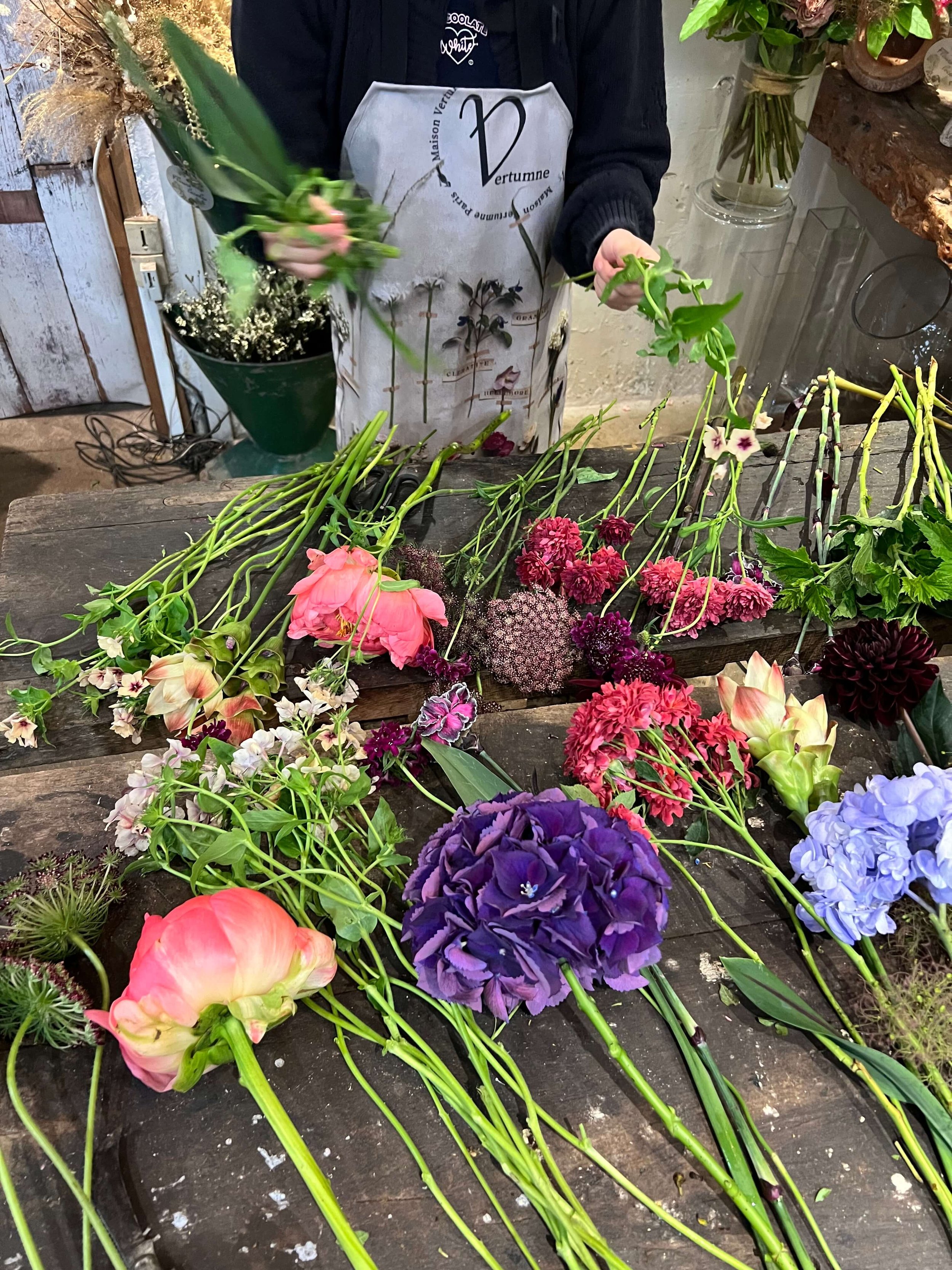 Préparation d’un cours d’art floral avec fleurs fraîches et tablier Vertumne. Immersion dans l’univers végétal.