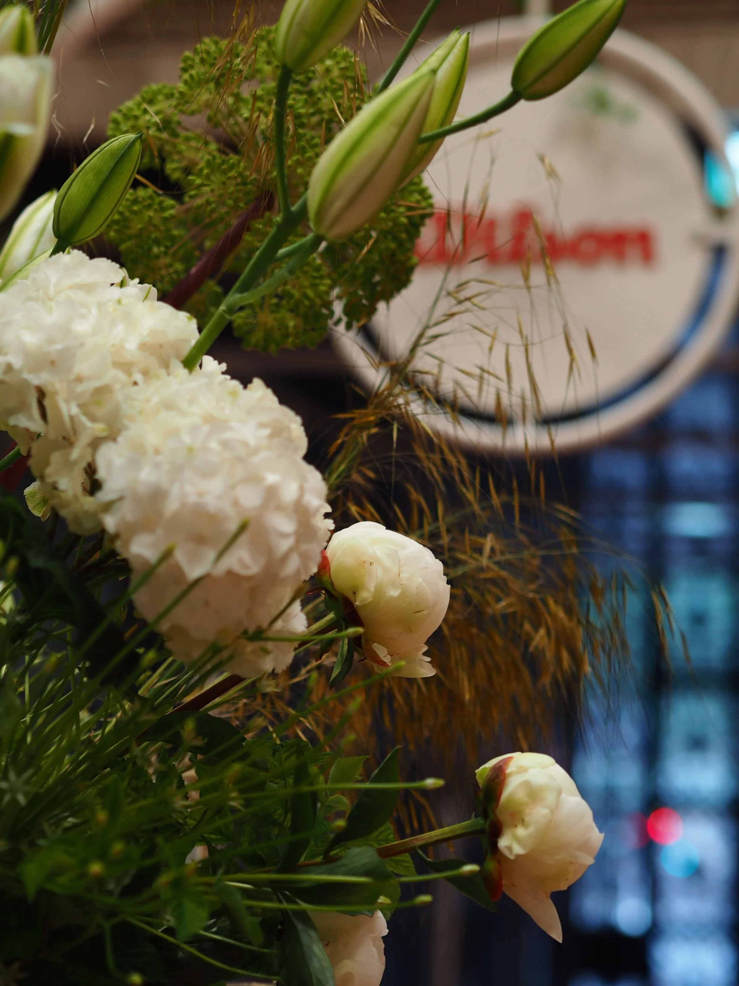 Fleurs blanches et boutons de lys dans un bouquet, avec un fond flou.