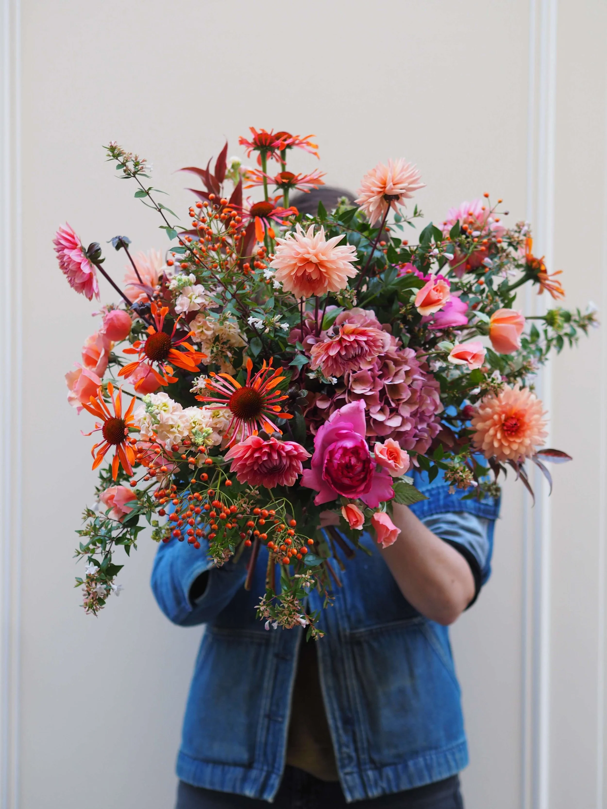 Personne tenant un grand bouquet de fleurs colorées