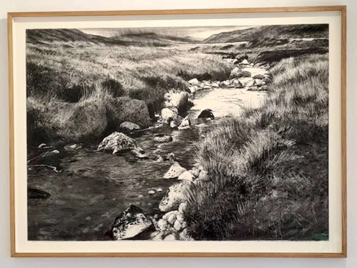 A detailed charcoal drawing by Michael Wannof a rocky moorland stream, in a natural oak frame with white mount by Image Framers, Sligo