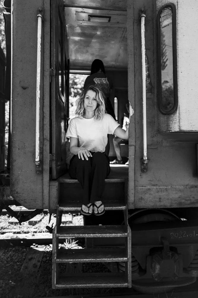ortrait en noir et blanc d’une femme assise dans l’encadrement d’une porte