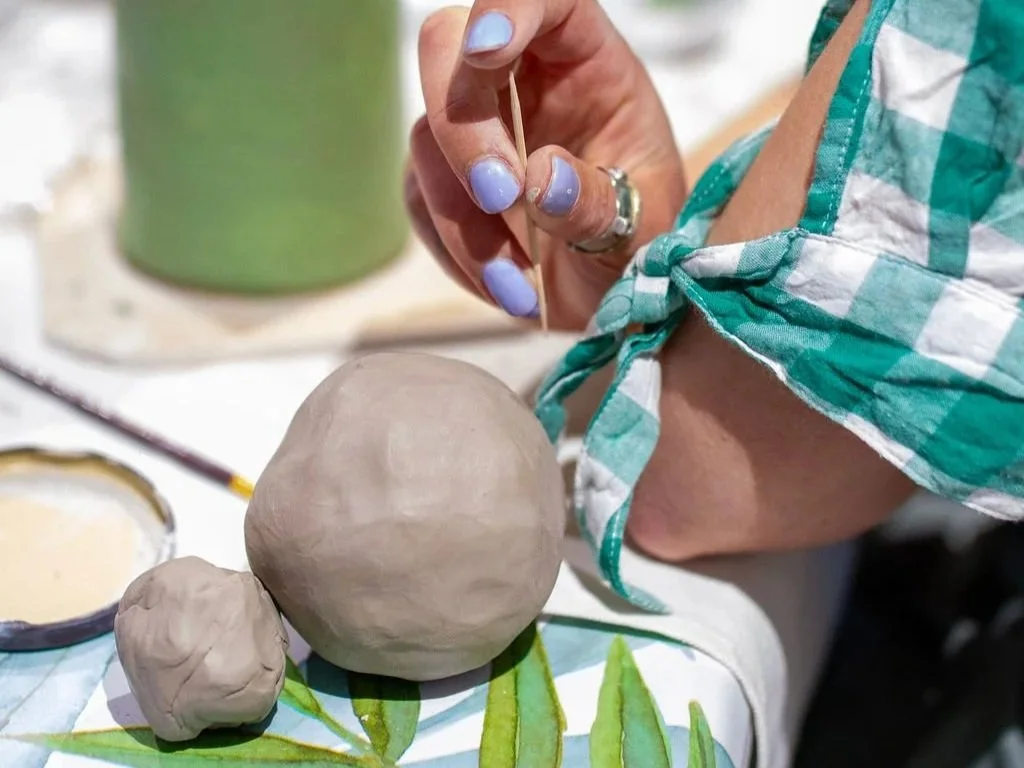 Corporate group participating in a mindful pottery workshop combining ceramic making and breathwork for workplace wellbeing