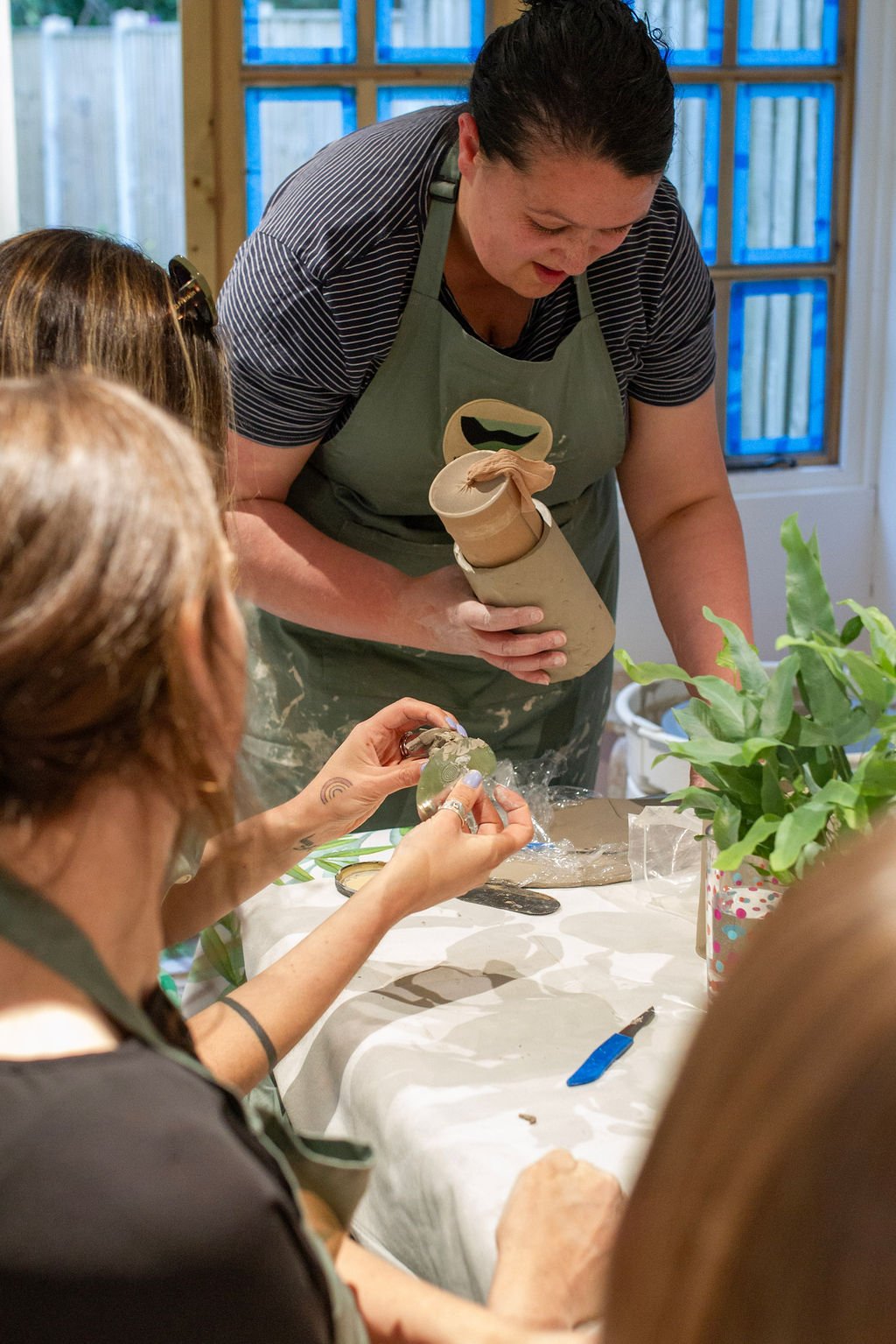 Potter leading a mindful team building pottery workshop in Manchester, with a corporate group creating ceramics together