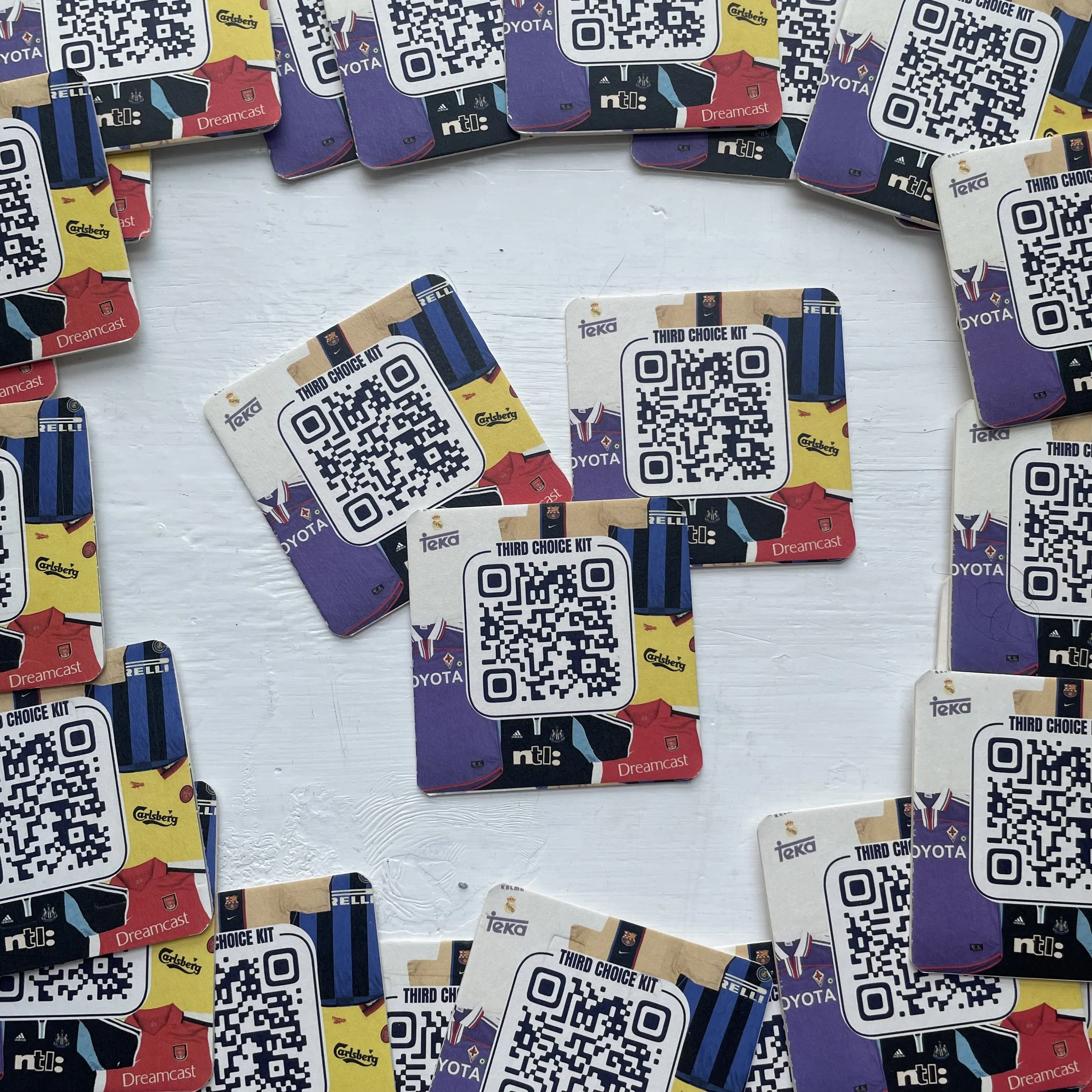 Collection of SEGA Dreamcast gaming accessories, including QR code stickers and promotional cards, featuring colorful graphics and logos.