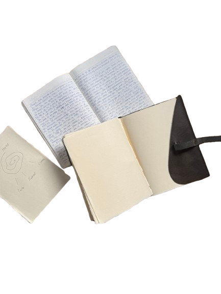 Open notebook with handwritten notes, an additional blank notebook, and a small notepad with sketches and notes.