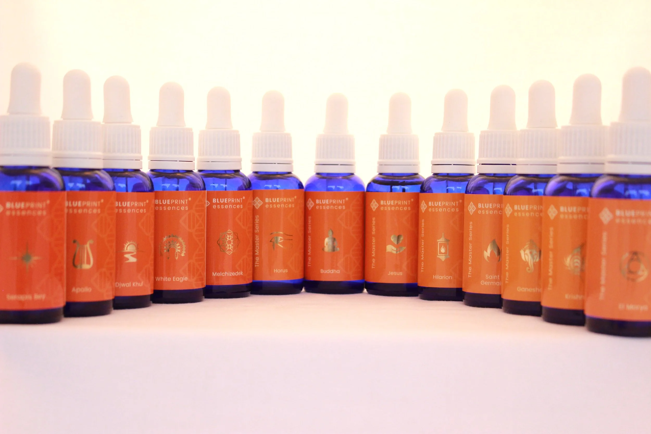 Blue glass bottles with dropper caps, labeled "Blueprint Essences," aligned in a row.